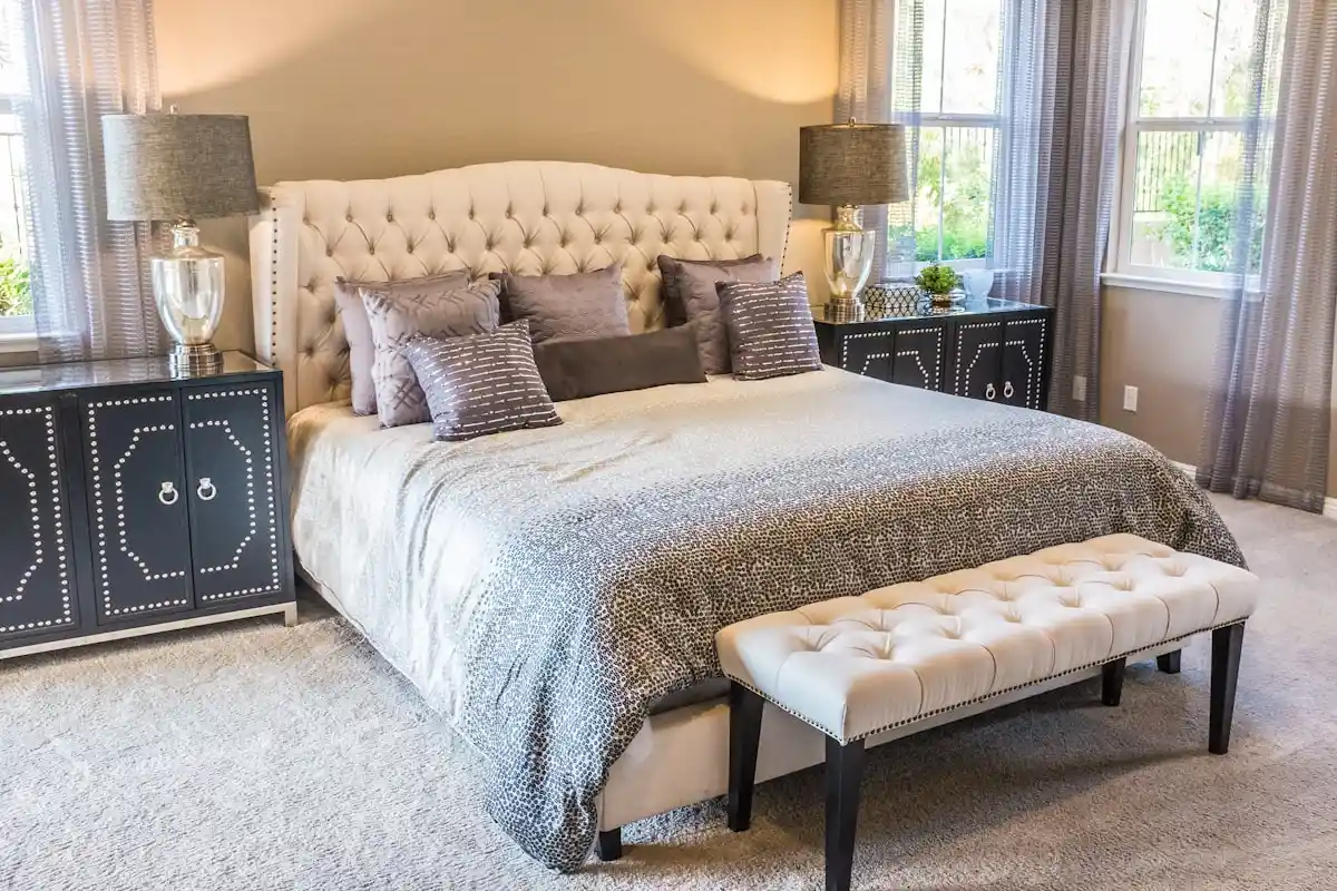 Serene master bedroom decorated according to the 60-30-10 color rule with neutral walls, layered linen bedding, and brass accents