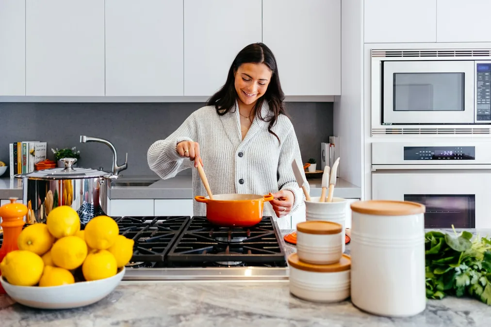 How to mix metal finishes in a kitchen featuring matte black cabinet pulls and warm brushed brass faucet