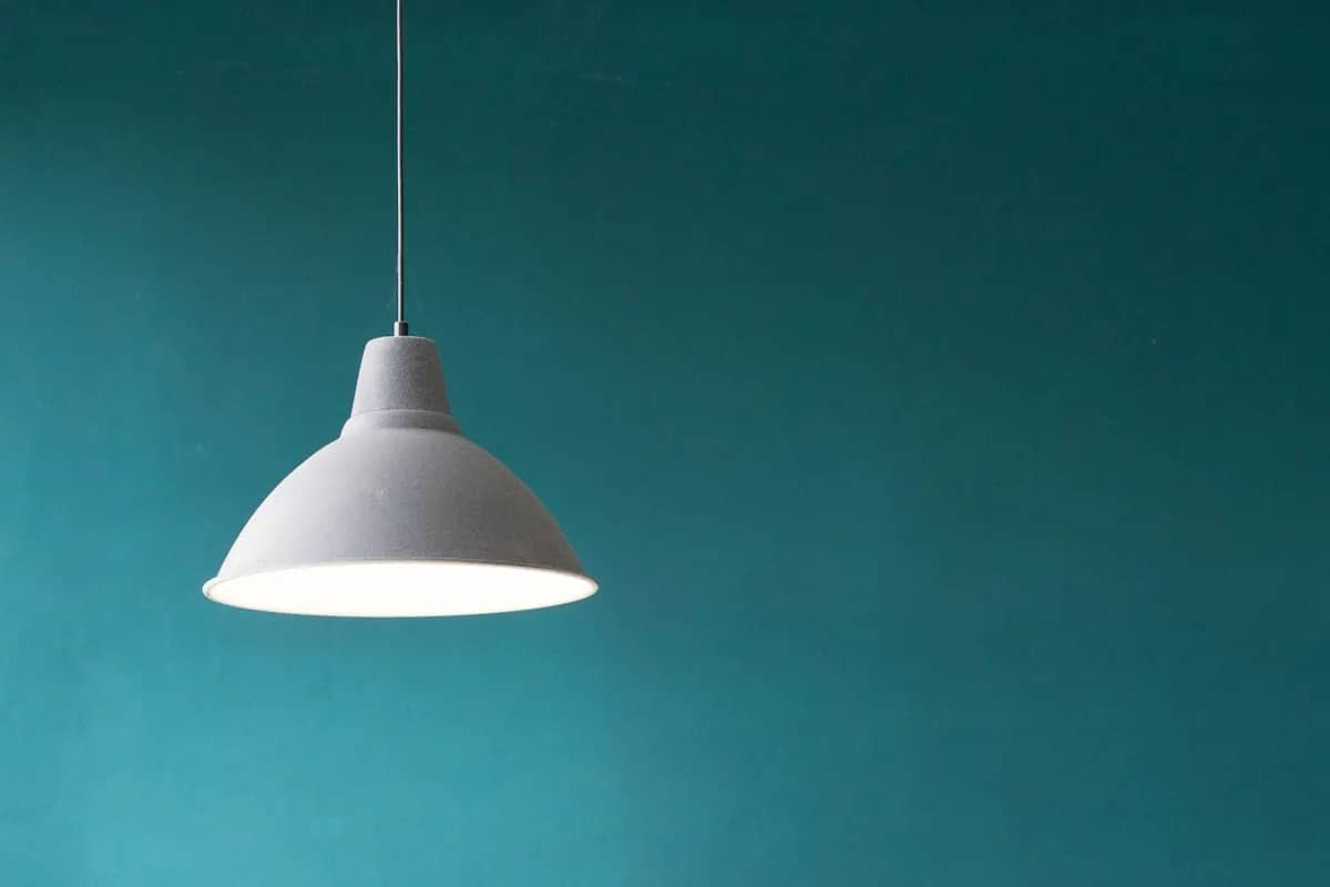Modern apartment dining space illuminated by a warm hanging pendant light fixture with soft overhead glow
