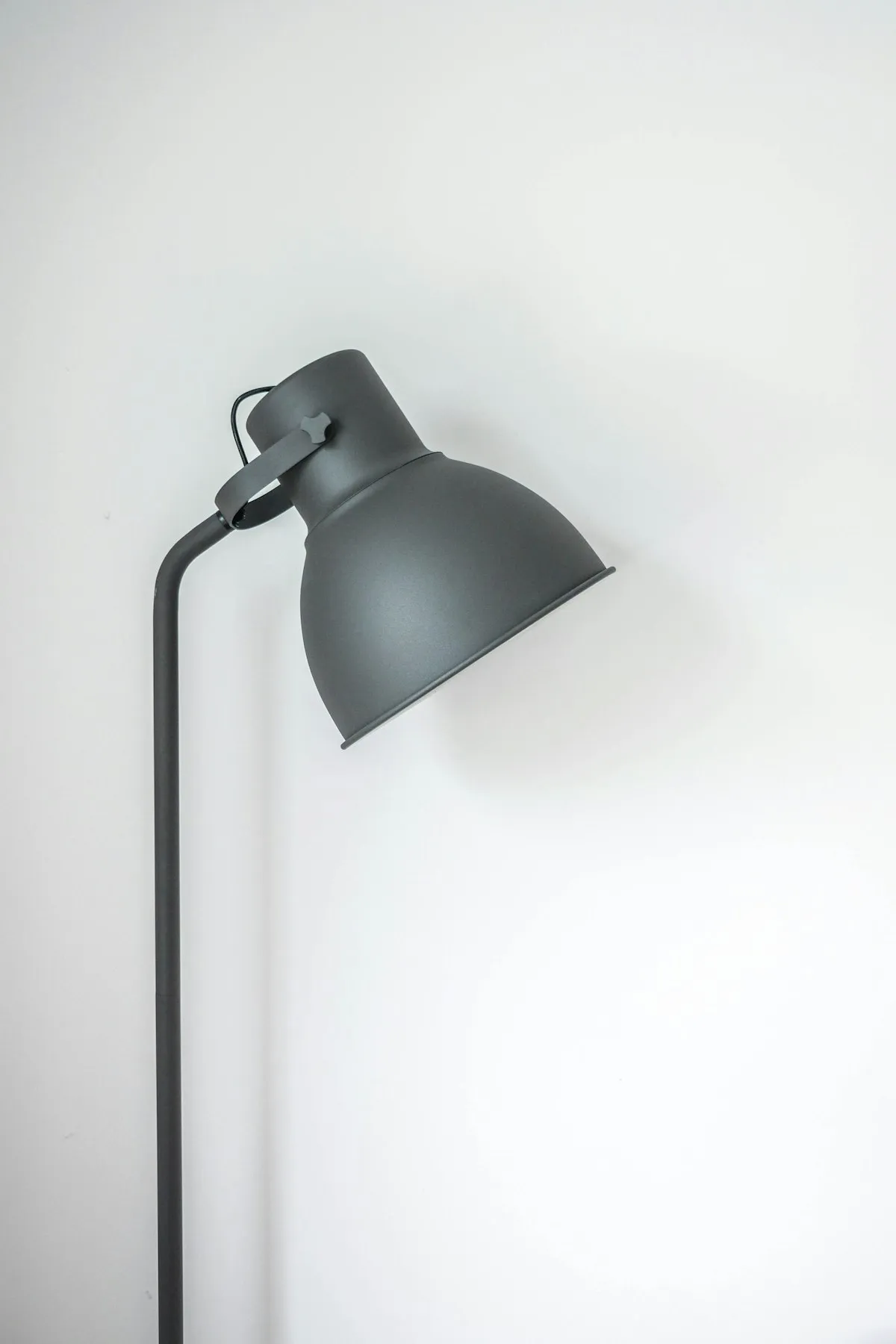 Modern ceramic table lamp emitting warm 2700K illumination on a wooden living room sideboard