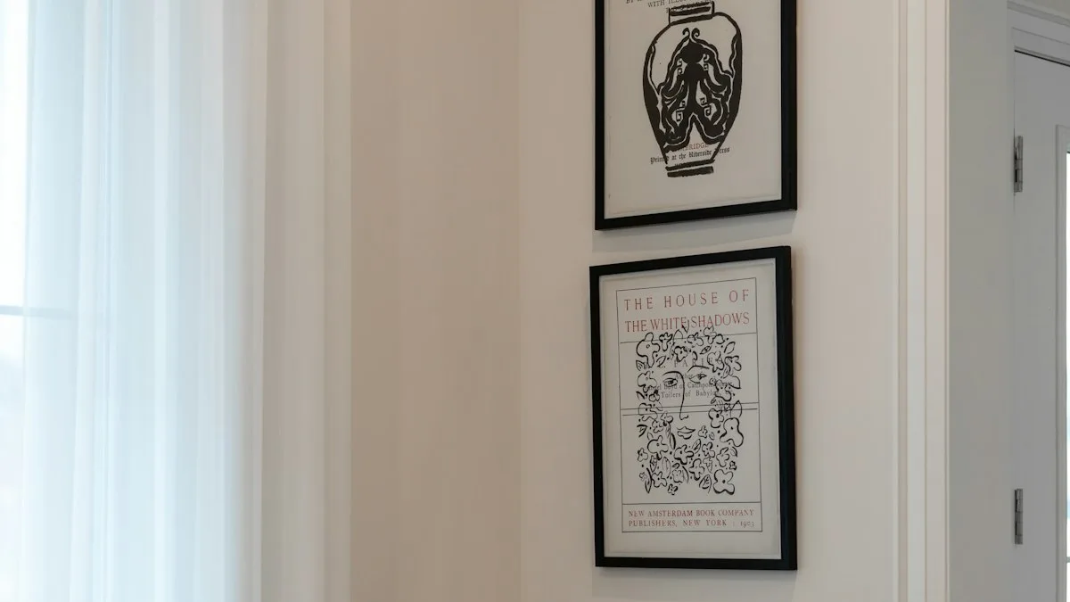 Framed art prints hung with precise uniform margin spacing and vertical alignment along an inside corner wall