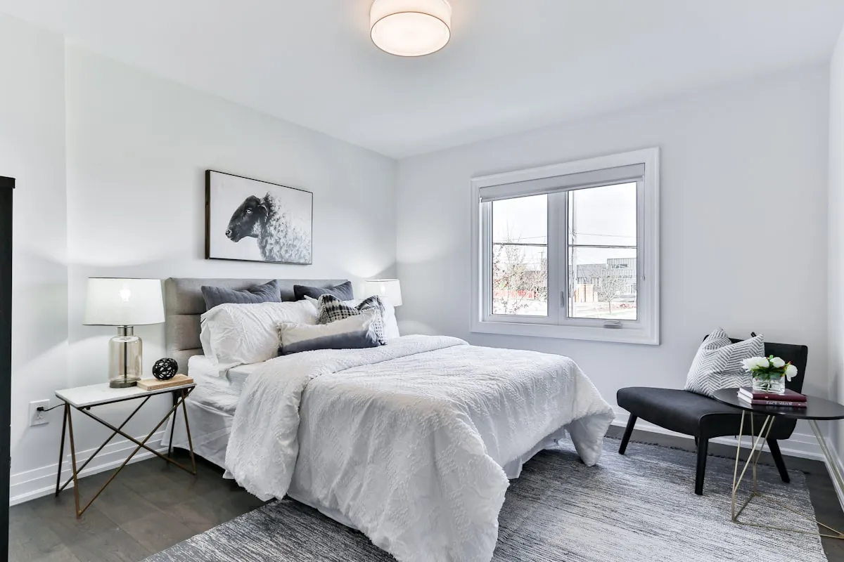 Cozy small bedroom layout featuring floating bedside lighting and tailored bedding to maximize floor space
