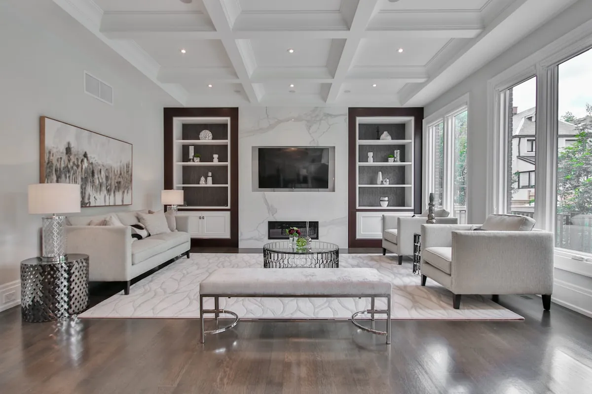 warm neutral color palette dark living room - Cozy living room with warm creamy oatmeal walls, boucle armchair, and natural light oak furniture